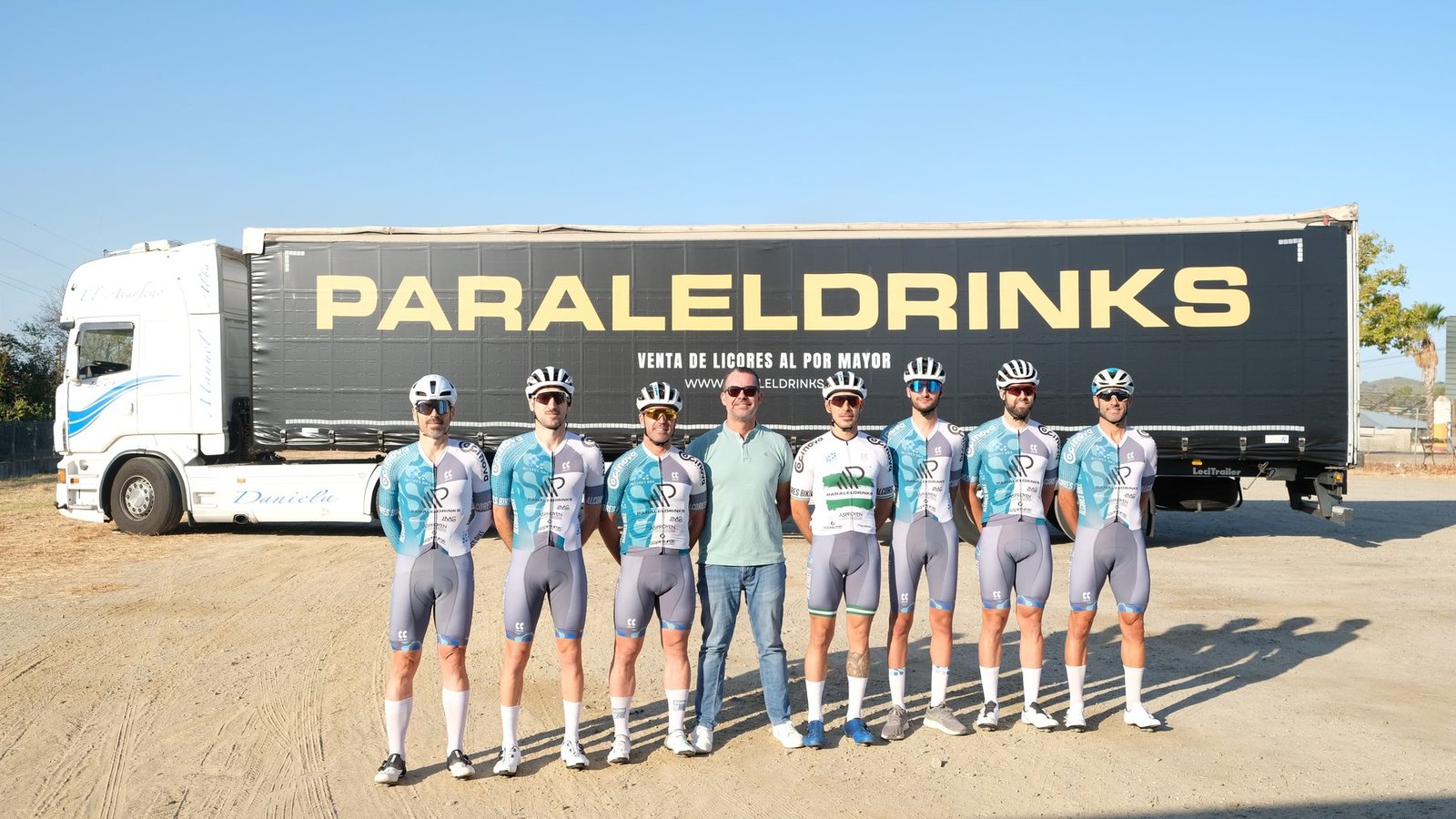 Juan Miguel, gerente de Paraleldrinks, con los corredores del Alcores Bike Paraleldrinks delante del trailer